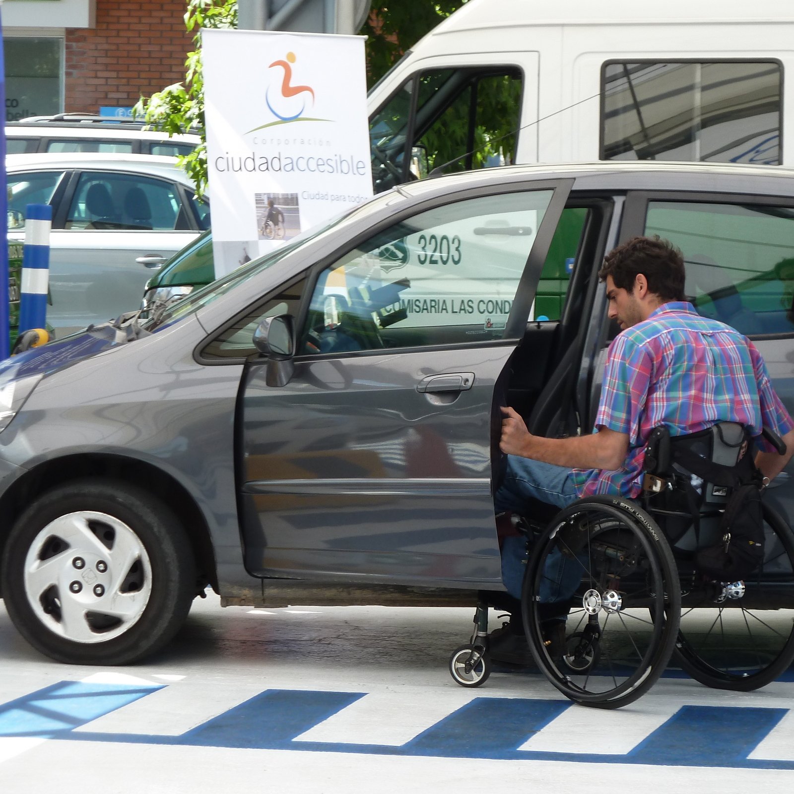 persona en silla de ruedas ingresando a su auto