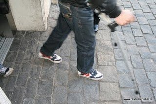 imagen persona con movilidad reducida sobre adoquines se ven los pies y muletas de una persona sobre una superficie de adoquines