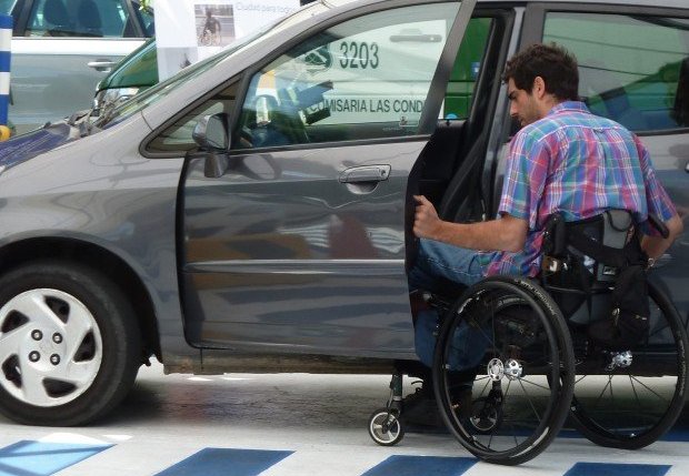 joven en silla de ruedas iniciando maniobras para subir a su auto