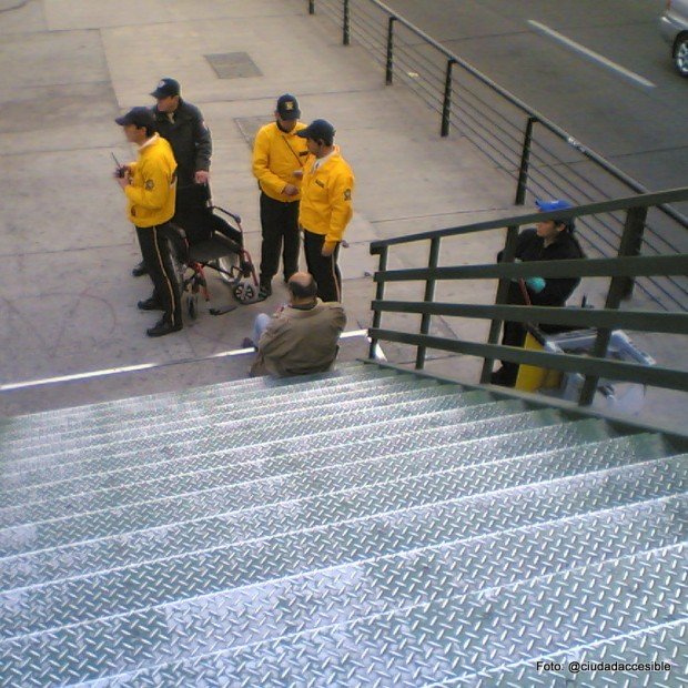 dos guardias junto a una persona que resbaló en la escalera de la pasarela peatonalrauco