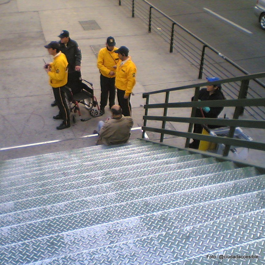 dos guardias junto a una persona que resbaló en la escalera de la pasarela peatonalrauco