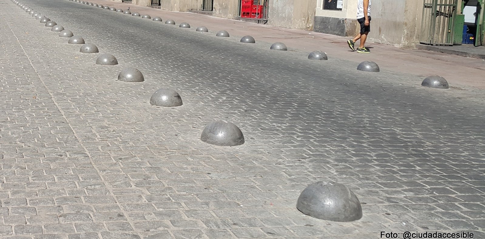 medias esferas grises separan la circulación peatonal de la vehicular