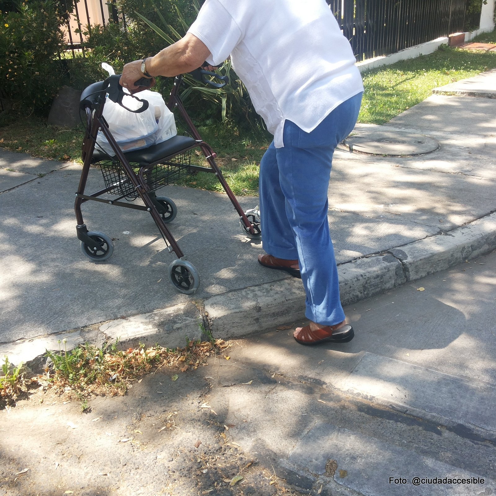 persona mayor con burrito intentando un cruce peatonal no rebajado