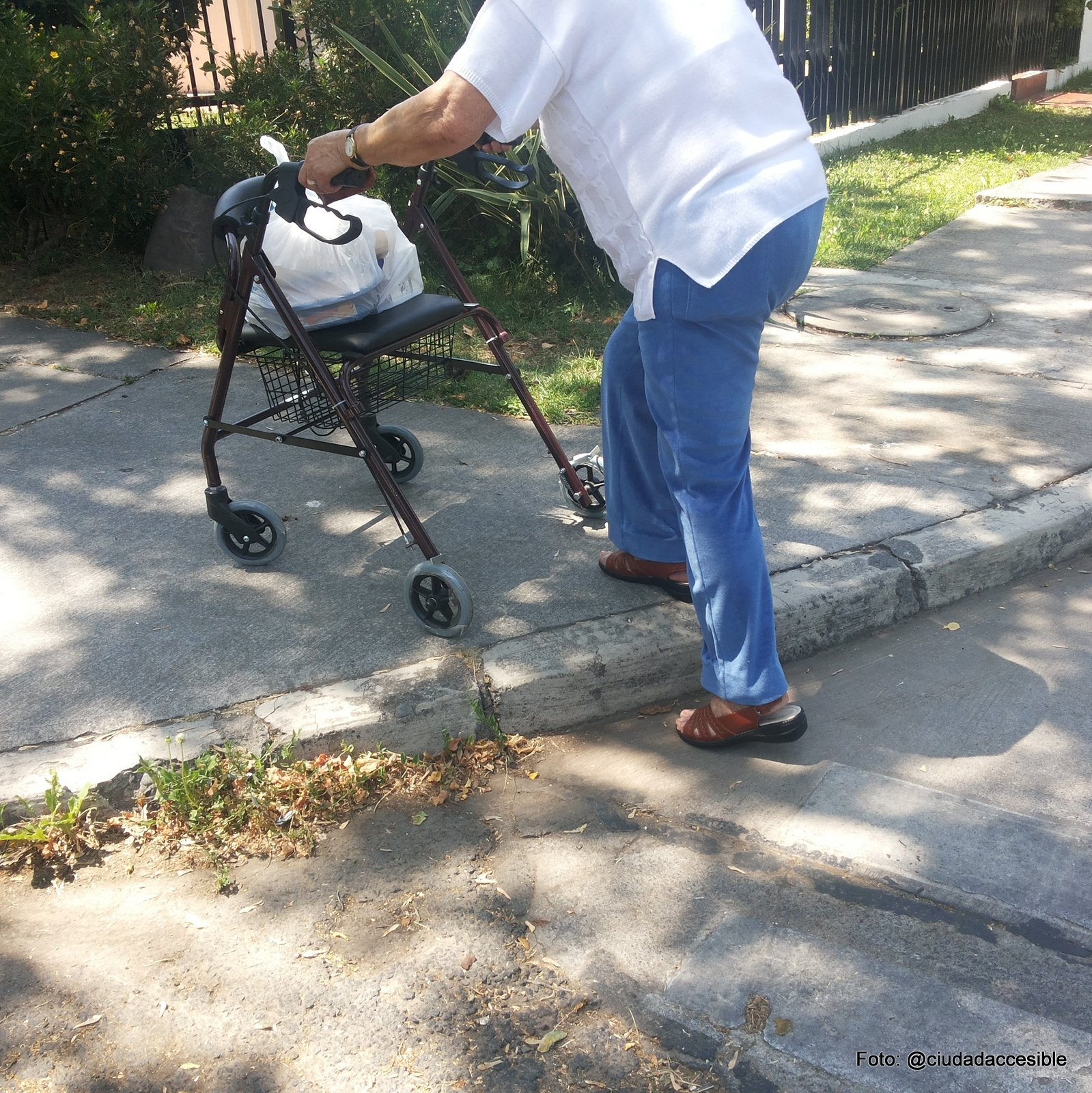 Persona mayor subiendo a una vereda con dificultad