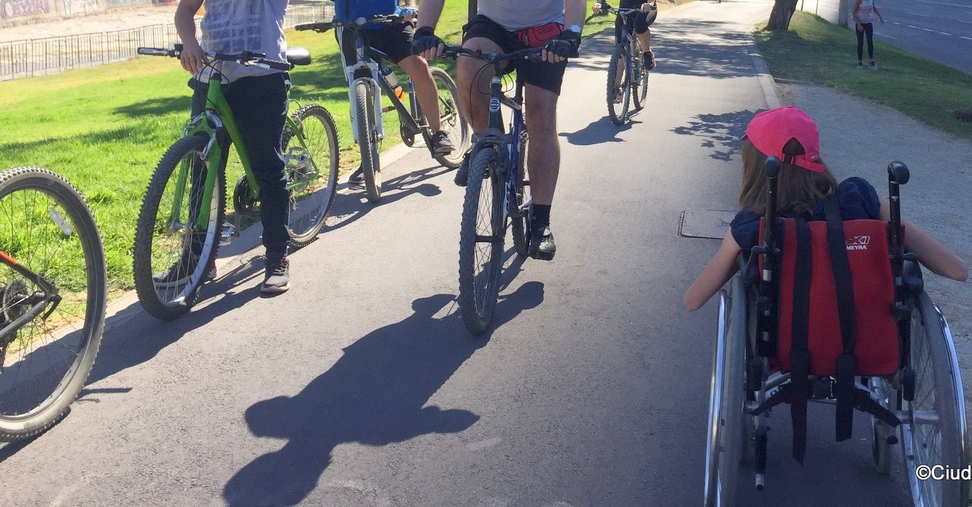 se ven varios ciclistas enfrentando a una silla de ruedas en sentido contrario