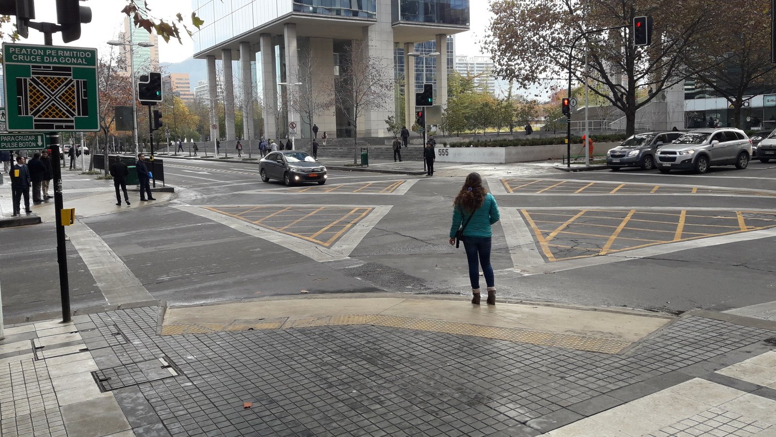 mujer enfrentando un cruce peatonal en diagonal en la intersección