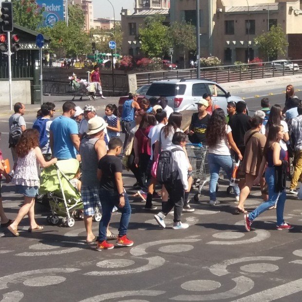 muchos peatones cruzando la calle por una demarcación en la calzada