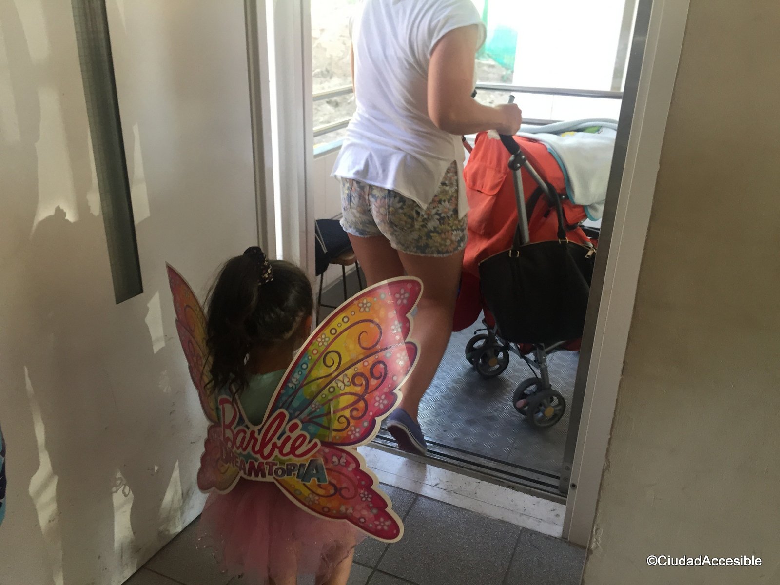 Foto de personas y un coche de niños accediendo al ascensor