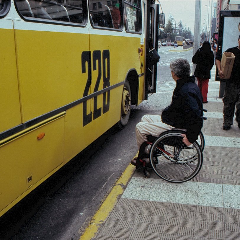 persona en silla de ruedas esperando transporte público
