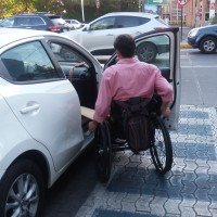 persona en silla de ruedas subiendo a un auto