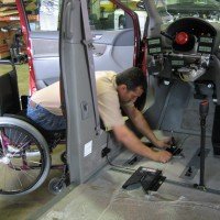 persona en silla de ruedas trabajando en un taller de automoviles