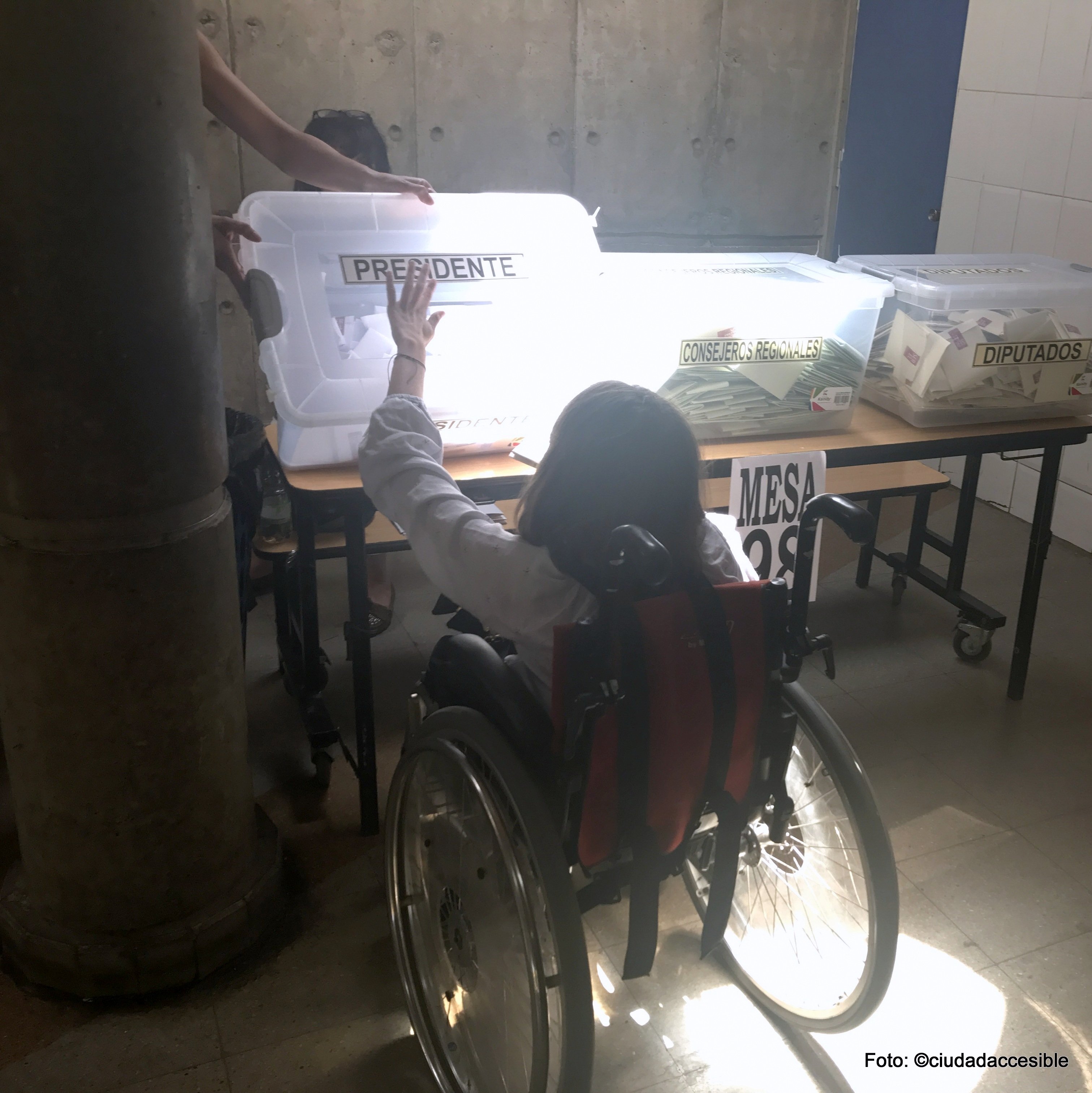 Joven en silla de ruedas deposita su voto