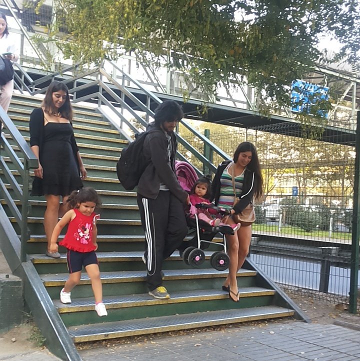 pareja bajando un coche de niños por una pasarela peatonal inaccesible