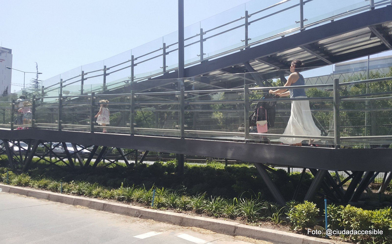 una mujer con coche y dos niños más suben por la rampa de la pasarela del parque arauco