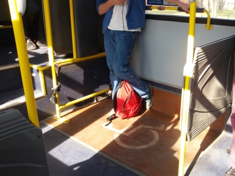 foto de espacio para silla de ruedas en bus con pasamanos de apoyo a una altura muy elevada