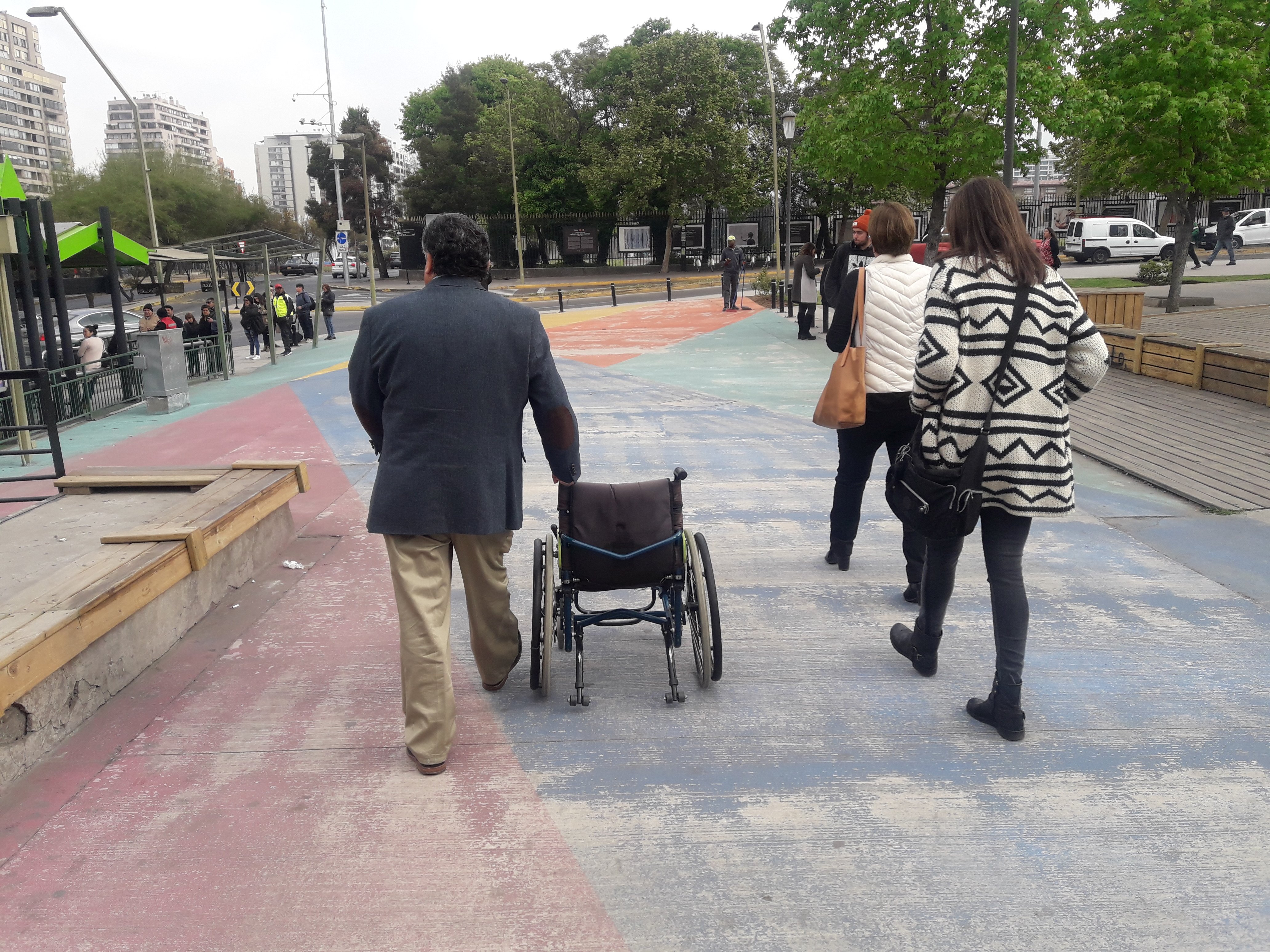 arquitecta claudia riquelme y directora de ciudad accesible en visita a terreno en calle apoquindo junto a miguel latapiat de la municipalidad de las condes llevando una silla de ruedas