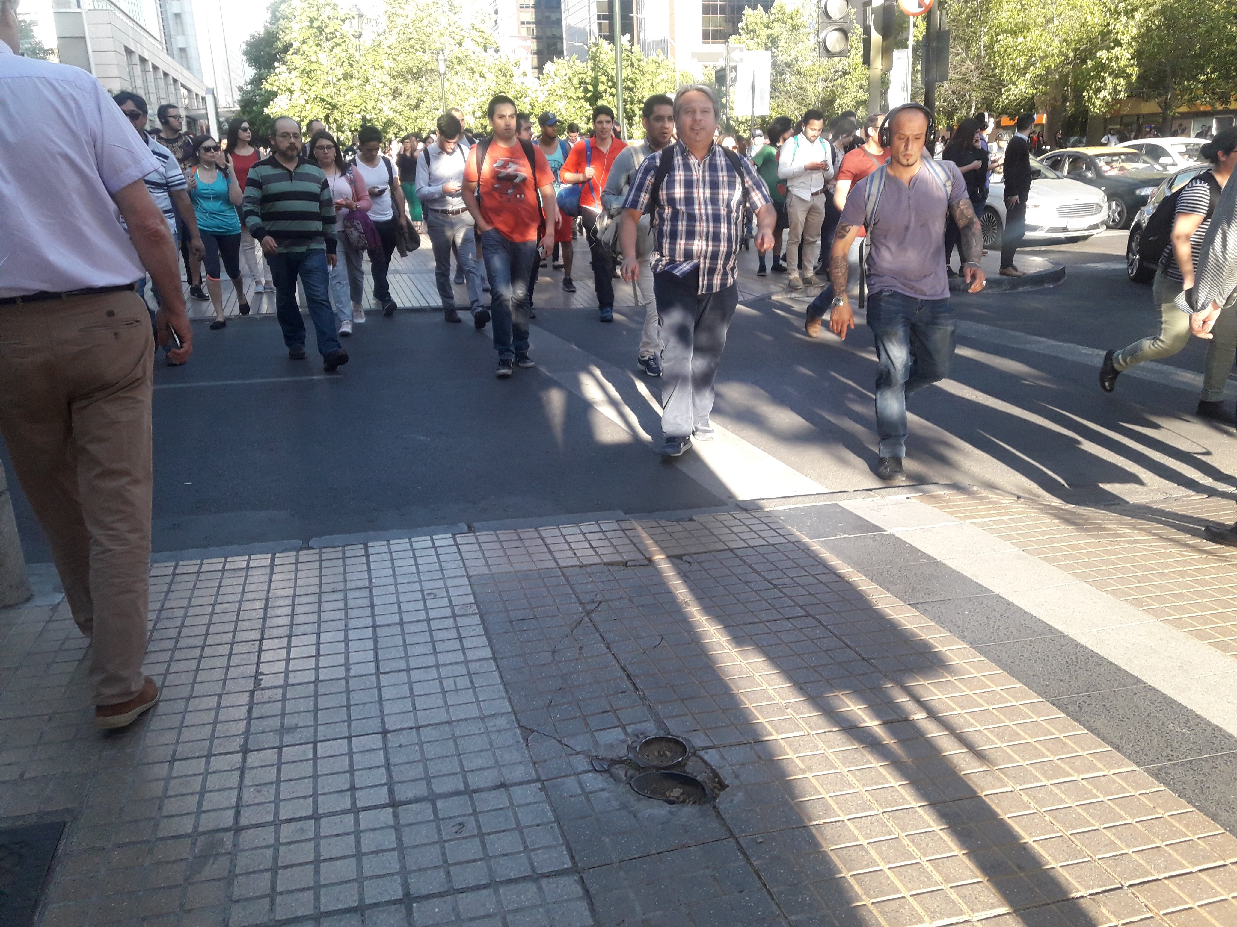 gran cantidad de peatones circulando por una vereda de las condes