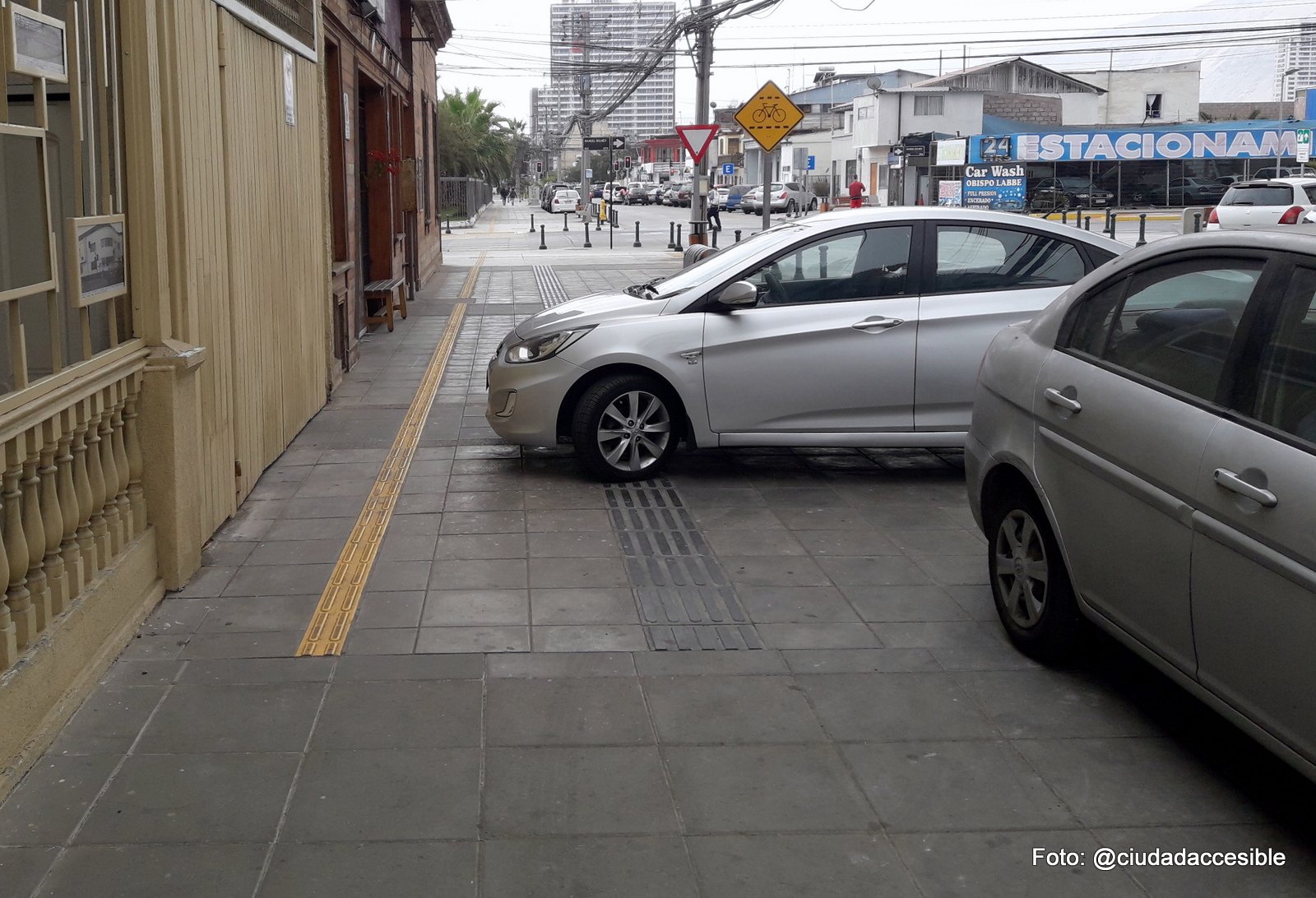 autos estacionados sobre la vereda uno de ellos casi encima de la guía táctil de avance