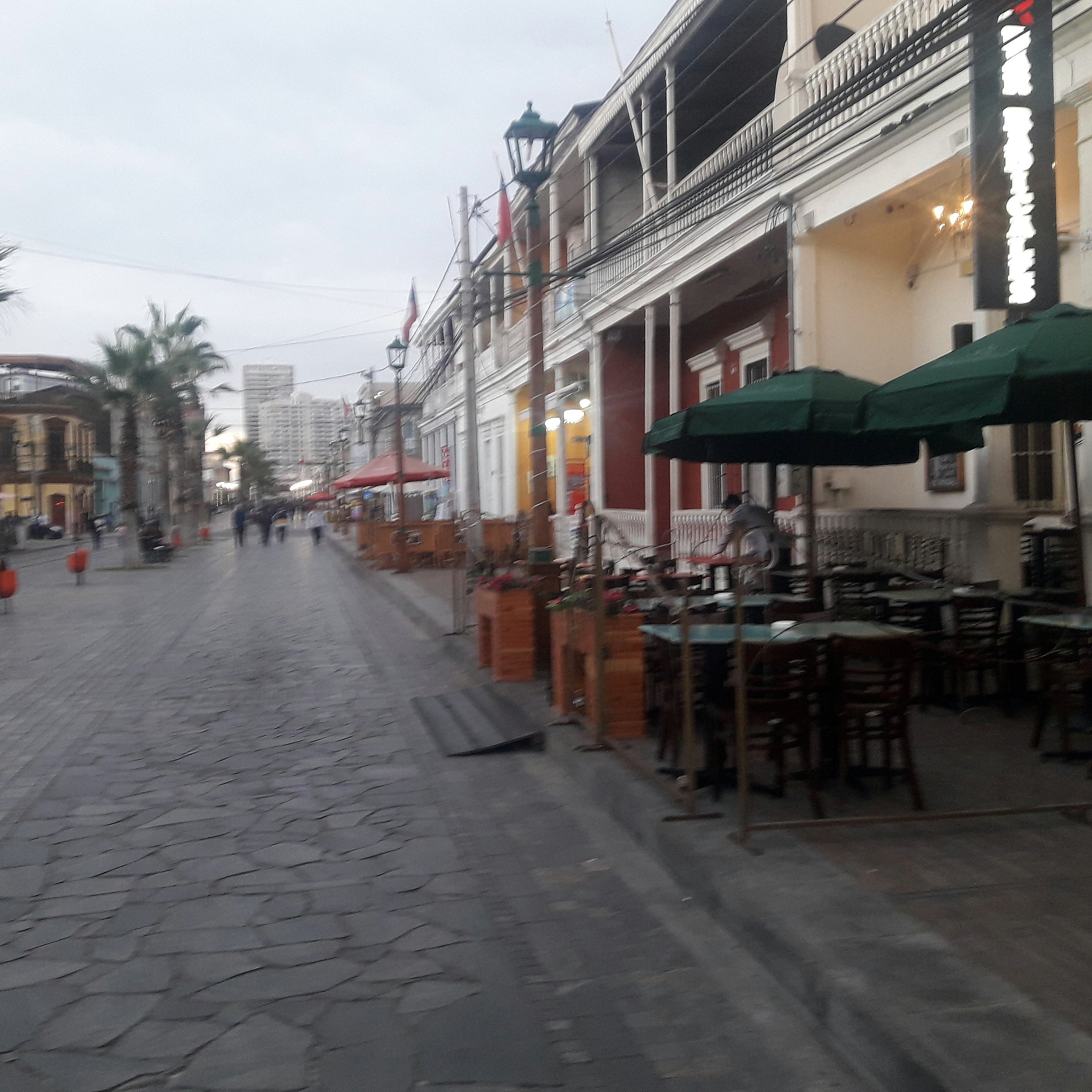 paseo peatonal con circulación sobre la calzada, la vereda es ocupada por mesas de un restaurant