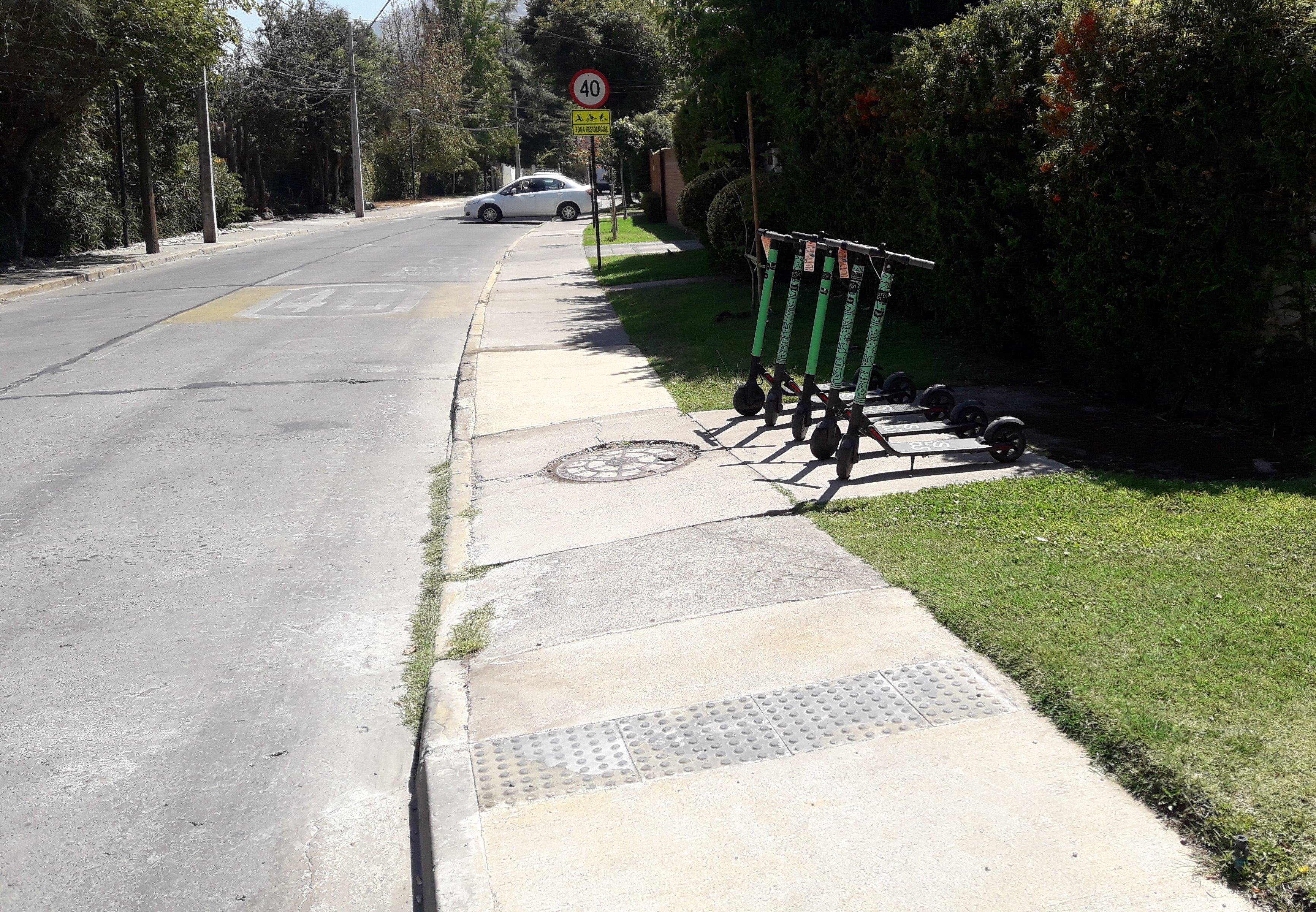 5 scooter estacionadas en un espacio contiguo a la vereda sin interrumpir el paso peatonal