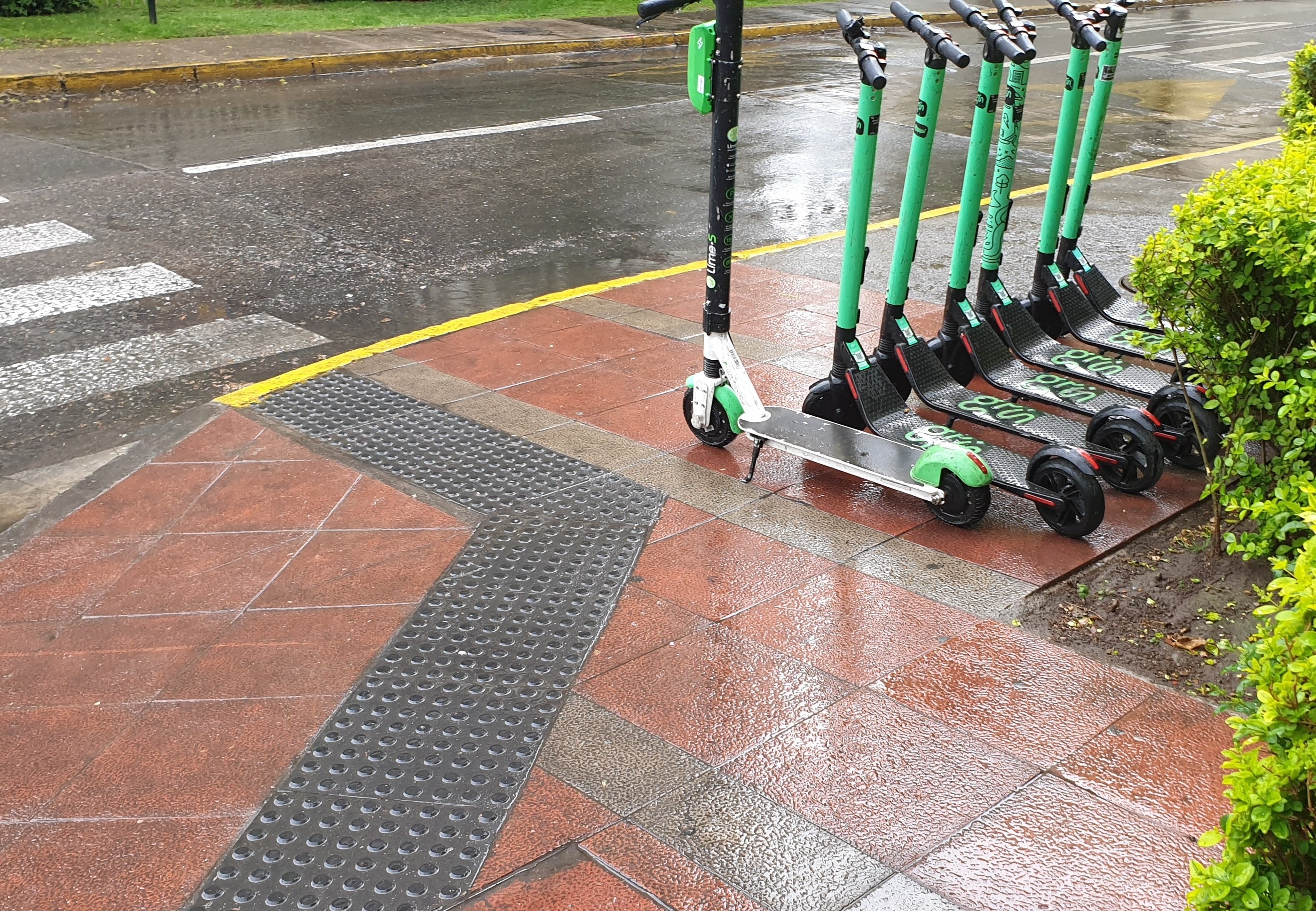 7 scooters ordenados sobre la vereda