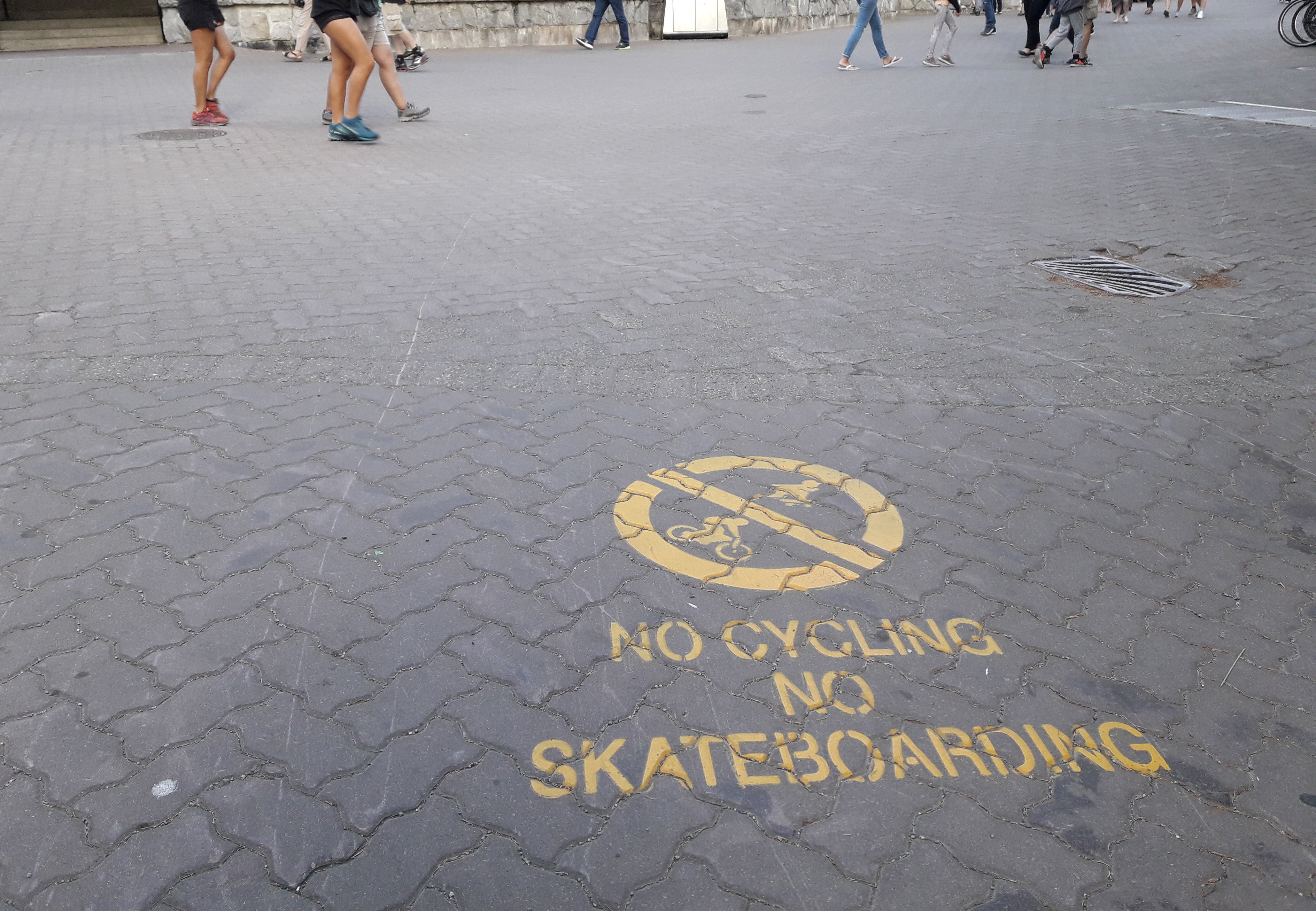 Señalización en el pavimento de un paseo peatonal que prohibe el uso de bicicletas o skate