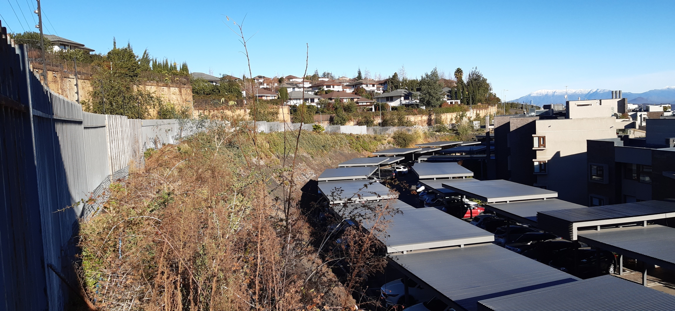 viviendas en un terreno con mucha pendiente. Un murallón separa la gran diferencia de altura entre éstas y la calle