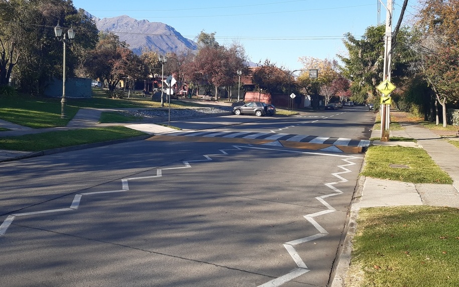 calle con un cruce peatonal a nivel de la vereda demarcado y señalizado