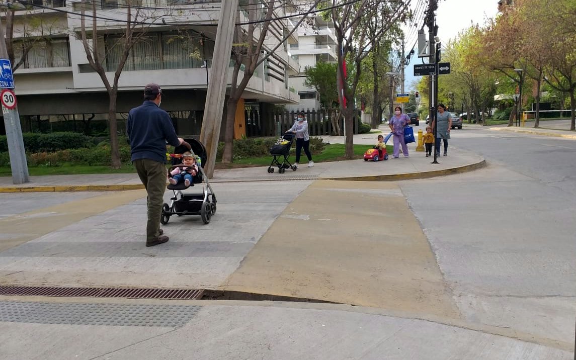 hombre lleva un coche d eniños sobre un cruce peatoal, enfrenta a una mujer que tambien lleva un coche