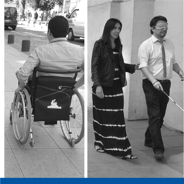 hombre en silla de ruedas y mujer guía a una persona que va con los ojos vendados y lleva un bastón guía
