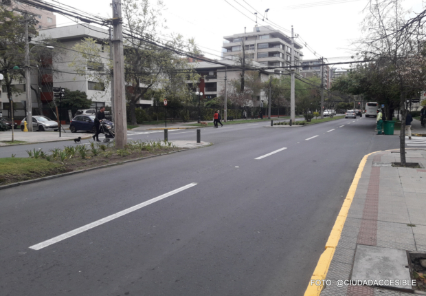 calzada doble con bandejón central y personas cruzando la calle