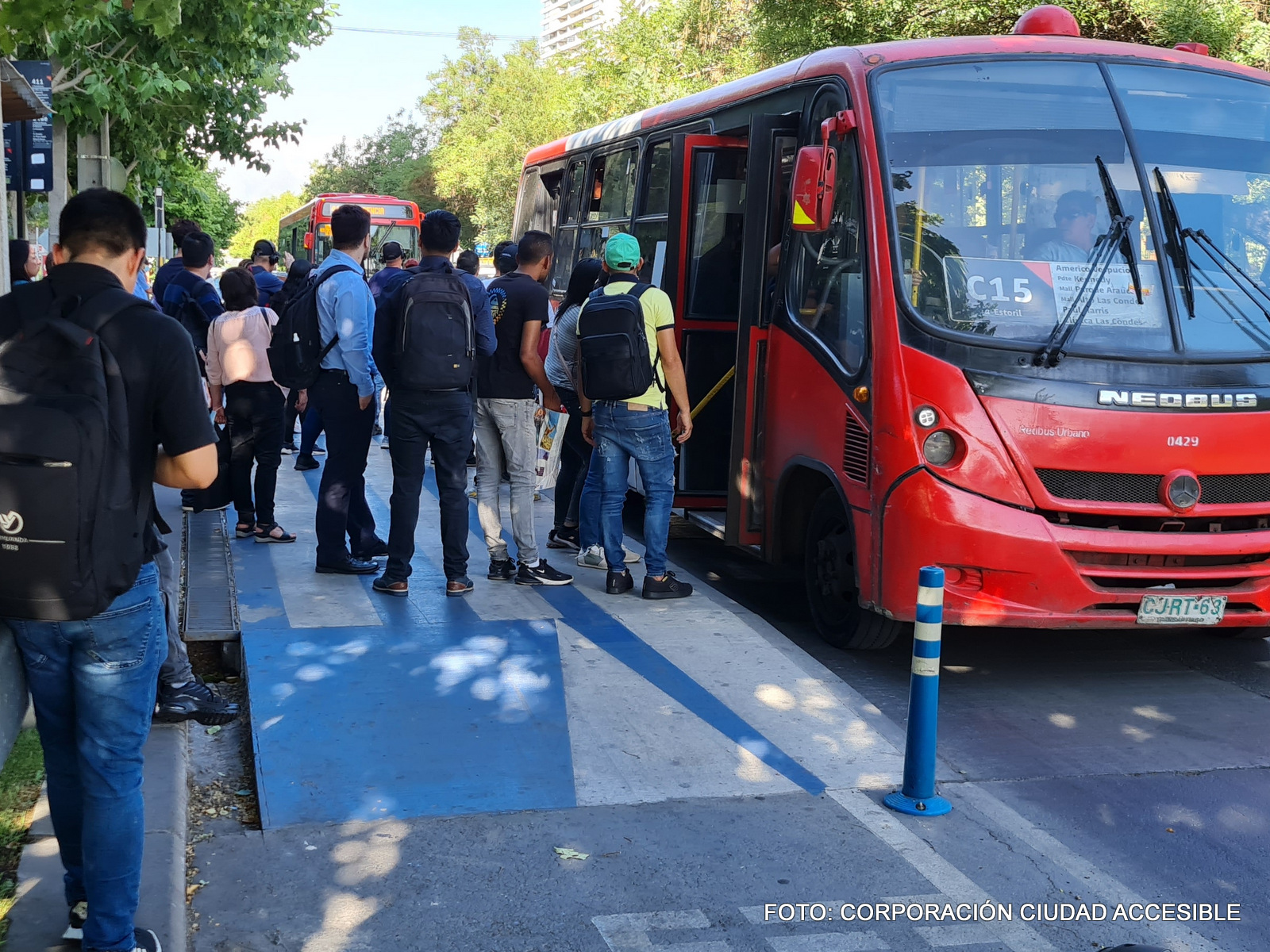 Muchas personas esperan sobre la ciclovía poder abordar un bus del transporte público