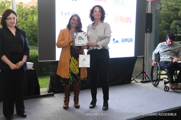 Andrea Legarreta entrega un libro a Daniela Cárdenas, directora d eFundación Yo soy Autismo