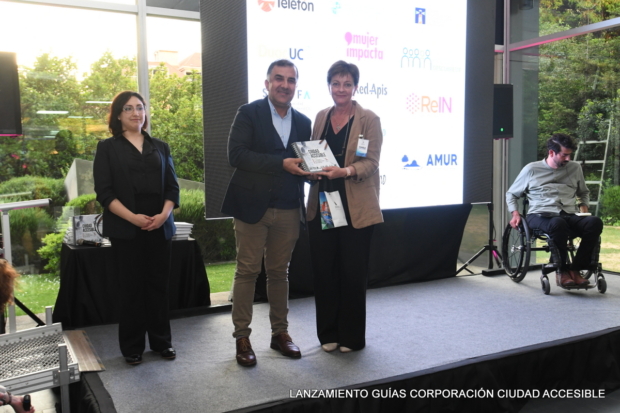 Pamela Prett entrega un libro a Aldo Orrigoni Director nacional de Gestión social y Voluntariado de Teletón