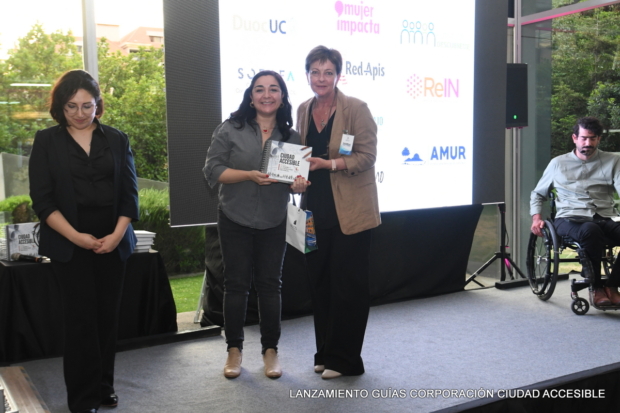 Pamela Prett entrega un libro a Catherine Mendy en representación del Comité de Inclusión Laboral CIL Sofofa