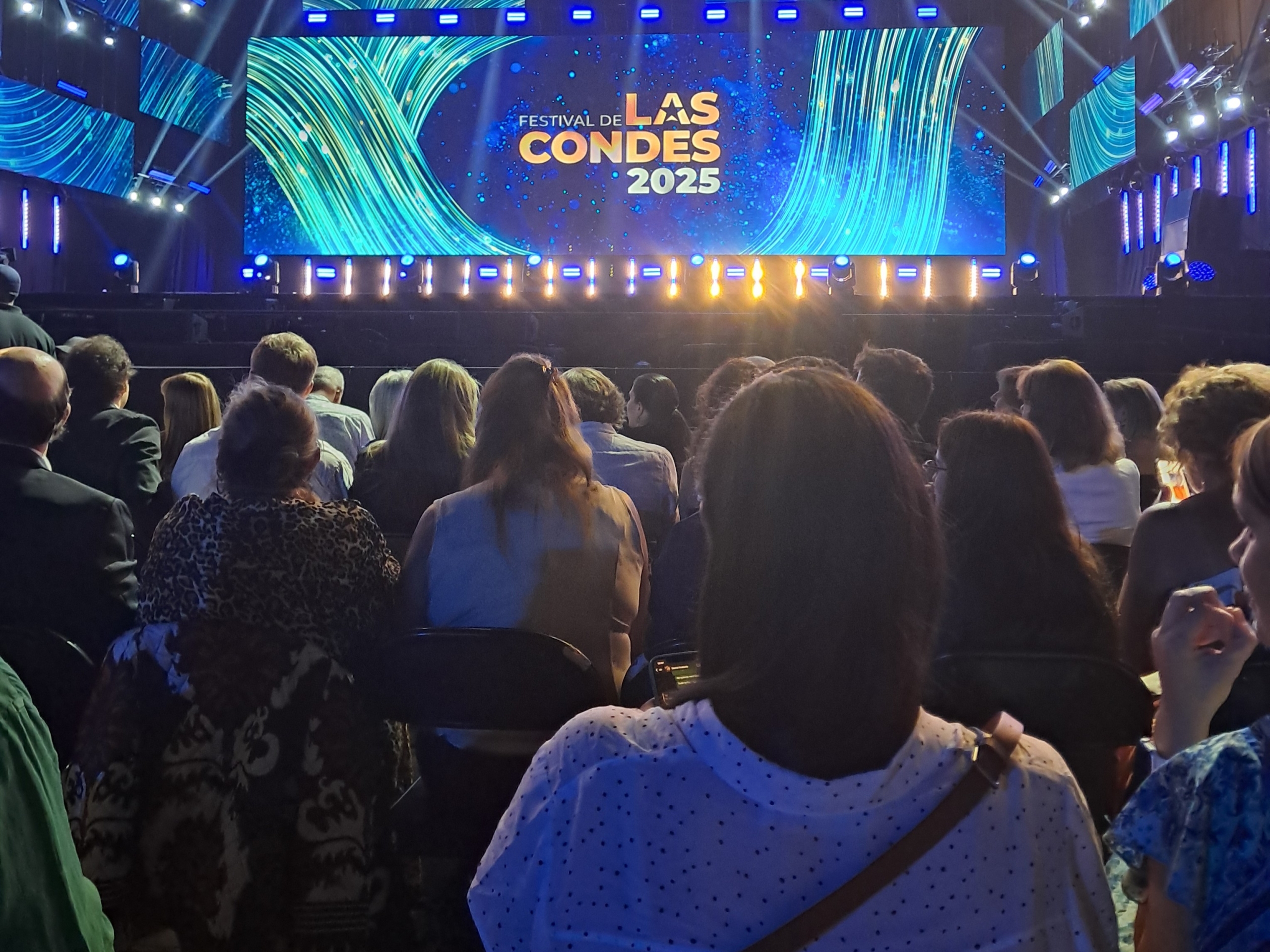 Se ven espectadores hacia un escenario con una pantalla gigante que dice las condes 2025